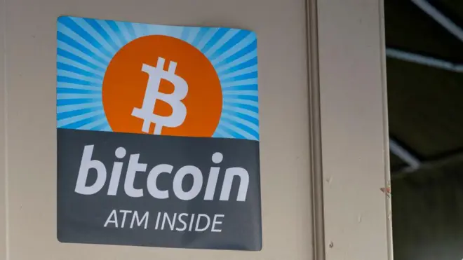 Uma placa indicando um caixa eletrônico de bitcoin no prédio