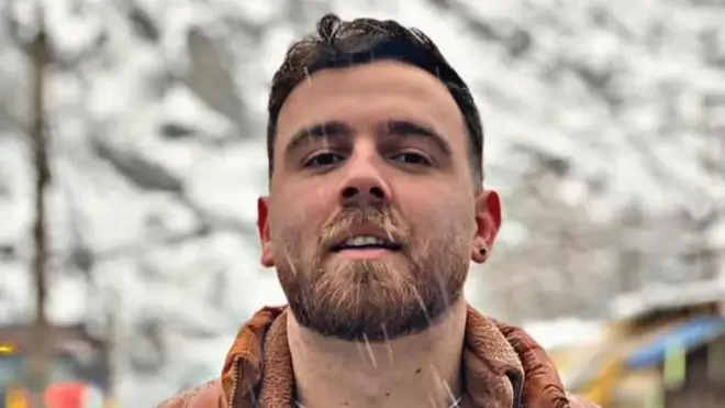 Erfan Soltani, um jovem de barba e cabelo castanho curto. 