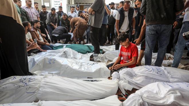 فلسطينيون يتجمعون أمام أكياس من الجثث في غزة
