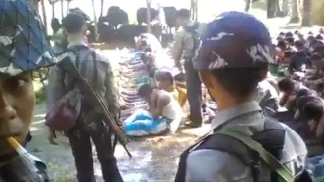 Dalam rekaman video, orang-orang Rohingya diperintahkan duduk berjajar dan kemudian dipukuli.