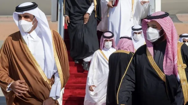أمير قطر وولي العهد السعودي لابسان كمامات ويبتسمون وهم واقفون جنبا إلى جنب