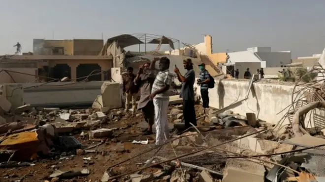 علاقے کے افراد ایک گھر کی چھت پر کھڑِ ہیں جس پر ملبہ دیکھا جا سکتا ہے