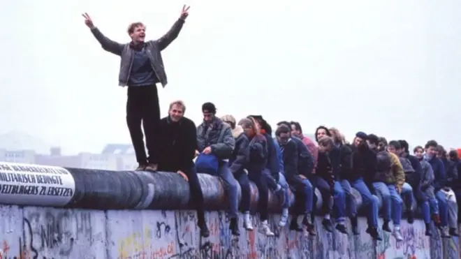 Jerman Barat merayakan keruntuhan komunisme di atas Tembok Berlin, tanggal 12 November 1989.