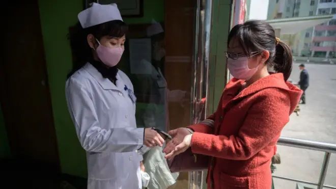 Seorang petugas kesehatan menyemprotkan disinfektan ke tangan seorang warga di tengah kekhawatiran atas virus COVID-19 di pintu masuk Rumah Sakit Rakyat Distrik Pyongchon di Pyongyang, Korea Utara.