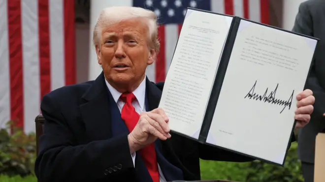 特朗普手举签署完成的宣布增加关税的行政命令书