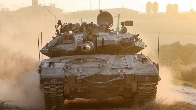 An Israeli military tank rolls near the border with the Gaza Strip on Sunday