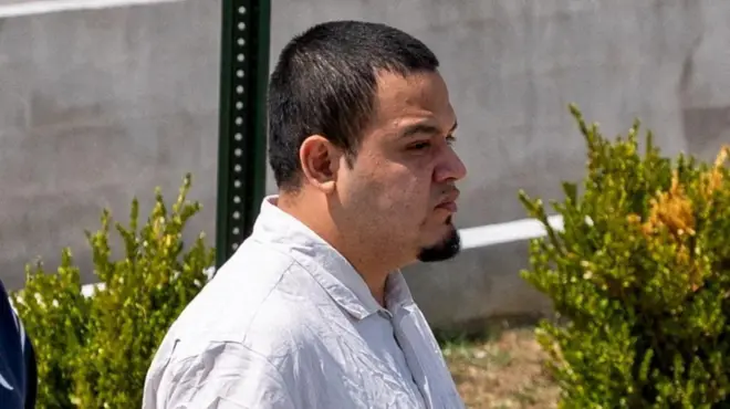 刑務所を出て屋外を歩くアブレゴ＝ガルシア氏。白いシャツを着ている。黒い短髪で黒いあごひげをたくわえている。