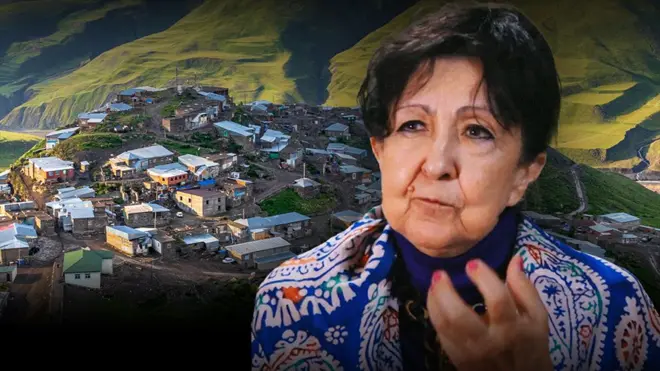 Женщина в традиционном платке на плечах разговаривает с другой женщиной 