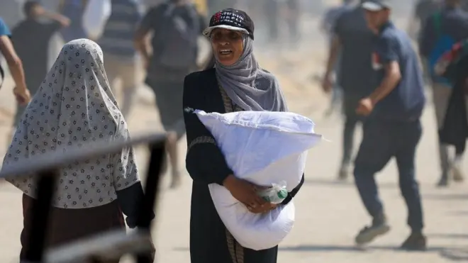 سيدة فلسطينية تحمل مساعدات