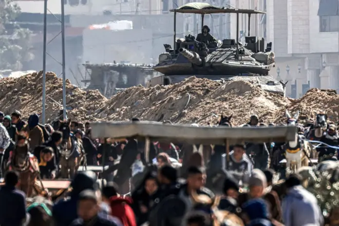 올해 1월 30일, 이스라엘군 탱크를 배경으로 칸 유니스에서 탈출하는 팔레스타인 난민들의 모습