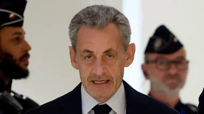 Close up de Nicolas Sarkozy vistiendo chaqueta y corbatas oscuras y camida blanca con rayas muy finas. Mira directamente a la cámara durante su llegada al tribunal de París, el 25 de septiembre de 2025, para escuchar el veredicto en su juicio por cargos de corrupción y financiación ilegal de una campaña electoral relacionada con la supuesta financiación libia de su exitosa candidatura presidencial de 2007.
