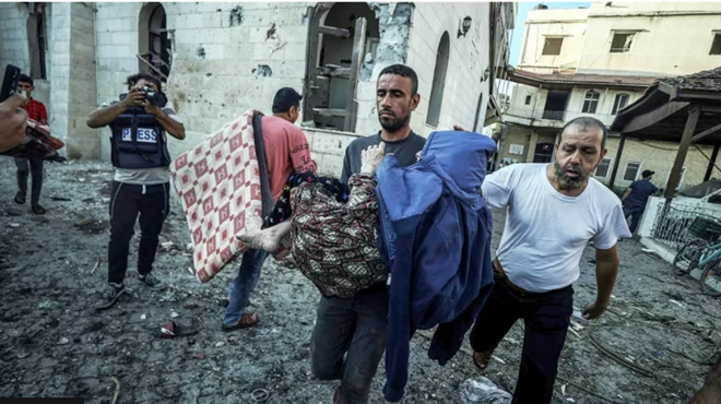 আল আহলি হাসপাতালের ধ্বংসস্তুপ থেকে একজনকে বের করে আনা হচ্ছে