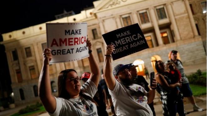 Supporters of U.S. President Donald Trump hold signs as they gather in front of the Arizona State Capitol Building to protest about the early results of the 2020 presidential election, in Phoenix, Arizona November 4, 2020.
