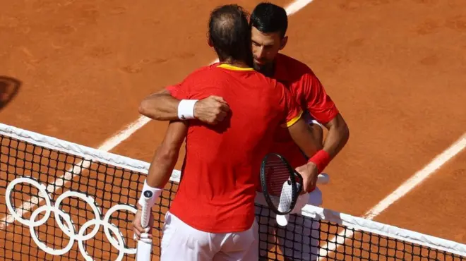 Zagrljaj velikih rivala na mreži terena na kojem su vodili mnoge duele