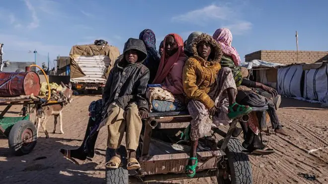 Des réfugiés soudanais nouvellement arrivés au Tchad, assis sur une charrette, s'apprêtent à retourner à leur abri temporaire après avoir reçu une aide alimentaire.