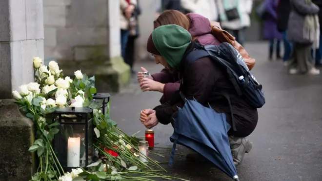 люди у стихийного мемориала жертвам пожара в Кран-Монтане