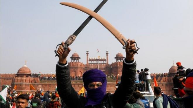 A farmer holds a sword during a protest against farm laws introduced by the government, at the historic Red Fort in Delhi, India, January 26, 2021