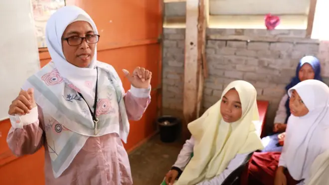 Pertama kali mengajar di depan kelas, kata Nur, membuatnya gemetar dan tidak bisa berbicara.