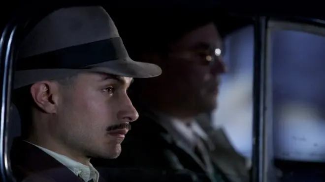 El mexicano Gael García Bernal interpreta al jefe de policía Óscar Peluchonneau, quien persigue a Neruda por todo el país.