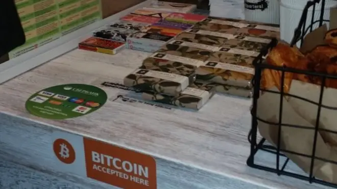 На прилавке кофейни висит знак, что здесь принимают биткоины