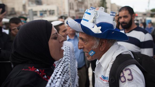 Perempuan pro-Palestina dan pria pro-Israel saling berteriak.