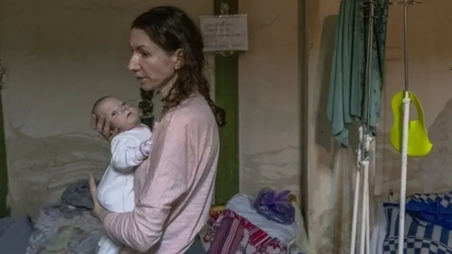 Катерина тримає на руках свою п'ятимісячну передчасно народжену дочку Діану в підвалі дитячої лікарні Охмадит, який перетворився на бомбосховище. 01 березня 2022 року