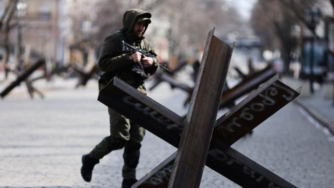 Um integrante do serviço ucraniano passa por uma barricada antitanque no centrobet+ apostasOdessa, Ucrânia, 20bet+ apostasmarçobet+ apostas2022