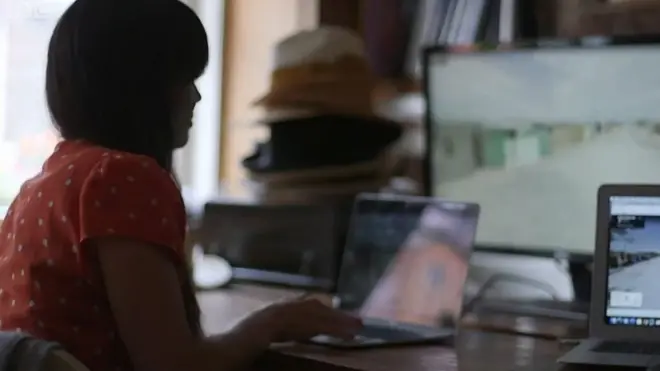 ผู้หญิงนั่งใช้คอม