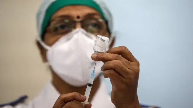 An Indian health worker mocks the vaccination process during a dry run of Covid-19 vaccination inside a Covid-19 vaccination centre at Rajawadi Hospital, in Mumbai, India, 08 January 2021.