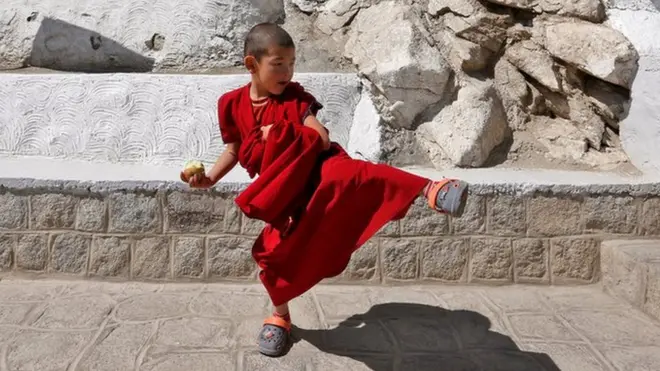 Niño monje practicando artes marciales.