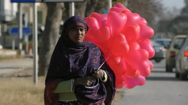 One Pakistani woman dey carry heart balloon for road on Valentine's Day for capital Islamabad for 2012