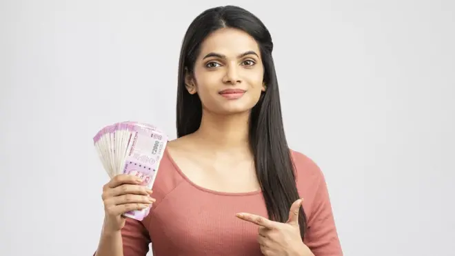 రెండు వేల రూపాయల నోట్లతో యువతి