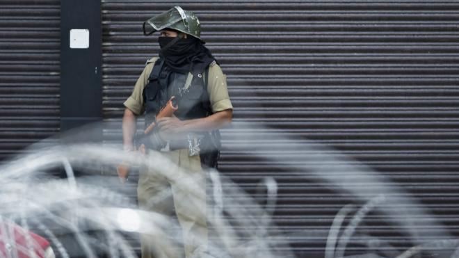 A security personnel stands guard on a street in Srinagar on August 28, 2019. - The Himalayan valley is under a strict lockdown -- with movement restricted and phone and internet services cut since August 5