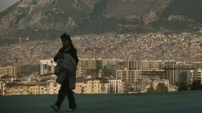 Antakya'da devam eden inşaatlar ve önünde yürüyen bir kadın