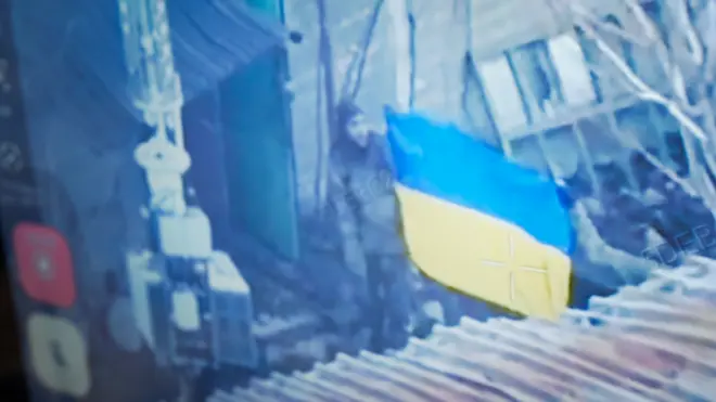 A Ukrainian soldier holds a Ukrainian flag