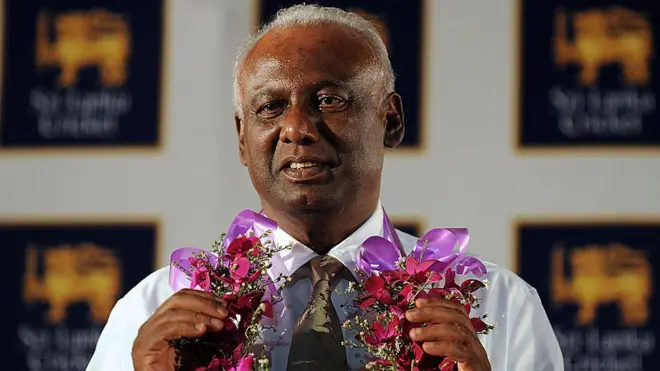 Jayantha Dharmadasa gestures with a garland following a press conference after elected to the top post uncontested in Colombo on April 16, 2013