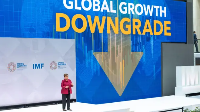 IMF總裁克里斯塔利娜·格奧爾基耶娃（Kristalina Georgieva）在華盛頓總部發表演說，背景電子幕牆展示著英文「全球增長降級」標題（9/4/2026）