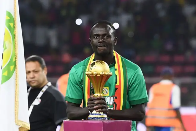 L'attaquant sénégalais Sadio Mané brandit le trophée avant la cérémonie de remise des prix après la victoire du Sénégal face à l'Égypte en finale de la Coupe d'Afrique des Nations (CAN) 2021, au Stade d'Olembe de Yaoundé, le 6 février 2022. 