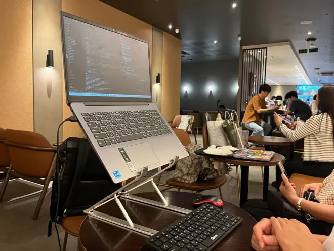 스타벅스 매장 안에서 한 손님이 노트북과 거치대, 키보드, 마우스를 갖춰 놓고 이용하고 있다.