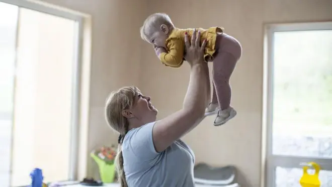 33-річна переміщена мати-одиначка з Донбасу грається зі своєю новонародженою дитиною Дарією в їдальні притулку для матерів-одиначок та вагітних жінок у Львові, Україна, 4 травня 2023 року.