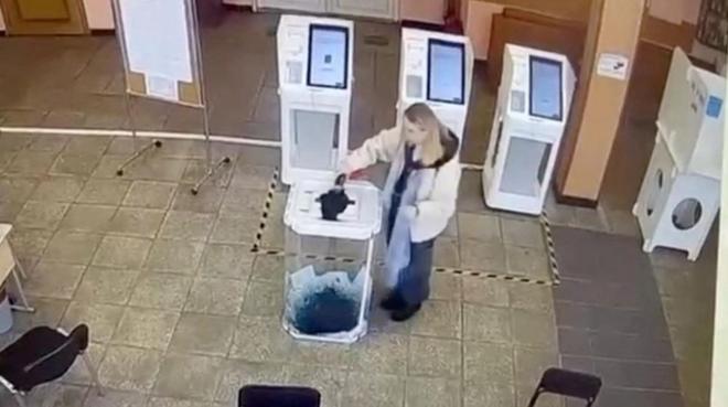 モスクワの投票所で投票箱に液体を注ぎ入れる女性