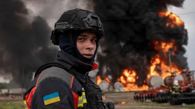 मे 2024 मध्ये युक्रेनच्या ईशान्य सुमी सीमेजवळील गॅस डेपोवर झालेल्या रशियन हल्ल्यामुळे लागलेली आग विझवण्याच्या कामात सहभागी झालेला युक्रेनच्या आपत्कालीन सेवेचा कर्मचारी दिसतो आहे.