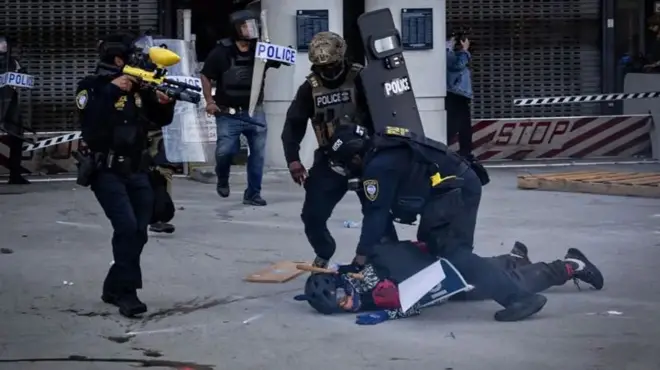 Immigration officers hols protester down sake of di demonstrations