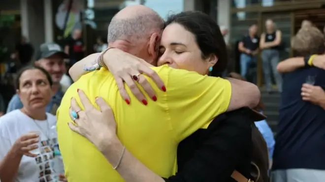 Umugabo urimo guhoberana n'umugore mu byishimo ko amasezerano yo guhagarika imirwano yagezweho hagati ya Hamas na Israel