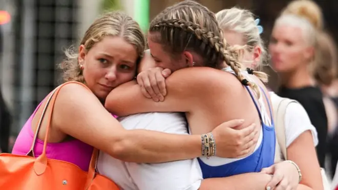 Campers embrace after arriving to a reunification area after floods in central Texas on 5 July 2025