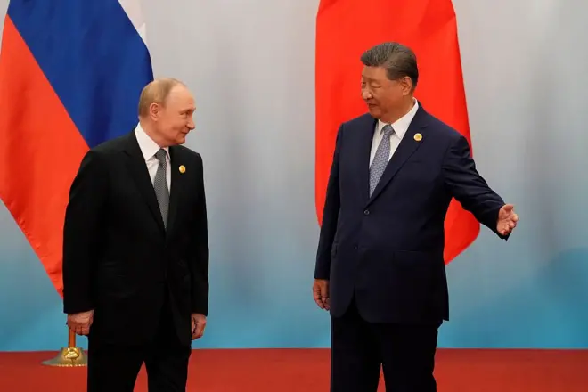 Perezida w'Ubushinwa Xi Jinping (iburyo) yereka aho kunyura Perezida w'Uburusiya Vladimir Putin akoresheje ikiganza. Ifoto yo ku itariki ya mbere Nyakanga (9) mu 2025, mu nama i Tianjin, mu Bushinwa. 