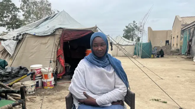 تجلس حواء أمام خيمة في مخيم للنازحين في بورتسودان.