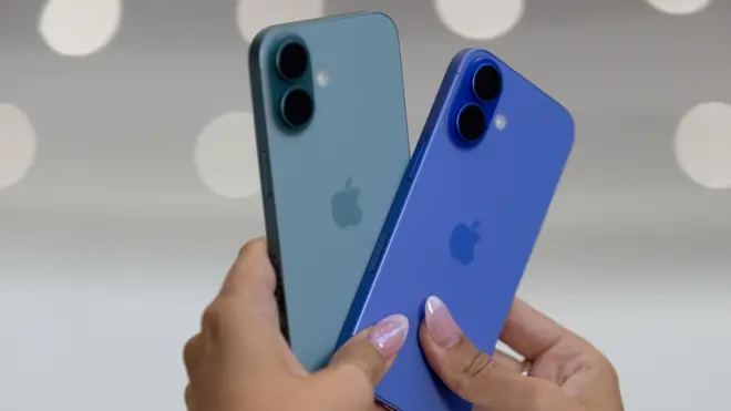 Les mains d'une femme tenant deux iPhones 16, en septembre 2024.