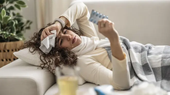 Koltukta yatan bir kadın, elinde mendil var