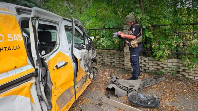 Поліцейський біля понівеченого авто